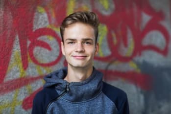Portrait of a smiling teenager on a background of a painted wall